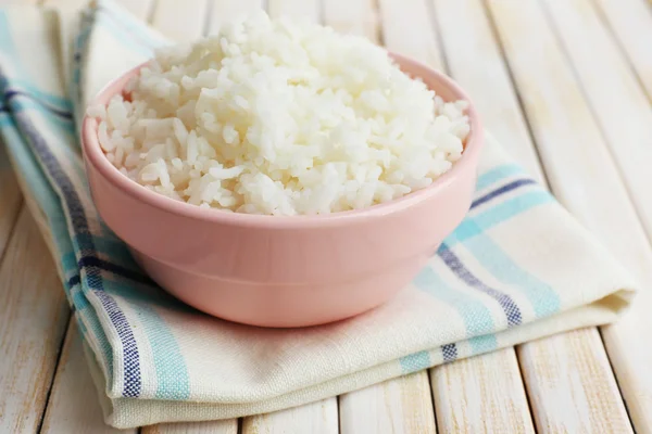 Cooked rice in bowl on wooden background — Stock Photo, Image