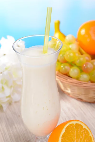 Batido de leite na mesa no fundo azul claro — Fotografia de Stock