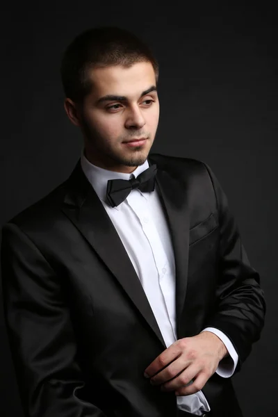 Hombre joven guapo en traje sobre fondo oscuro — Foto de Stock