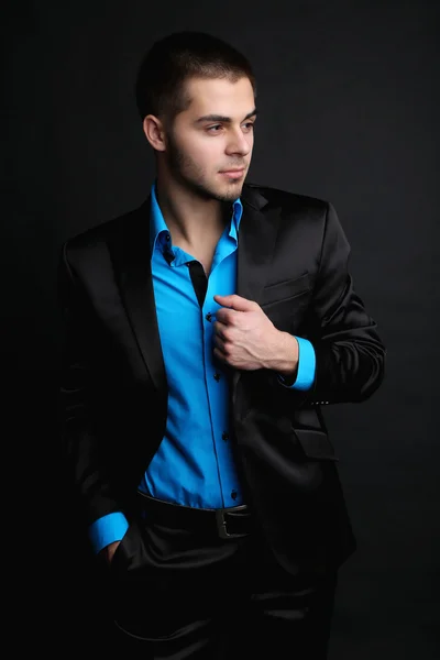 Hombre joven guapo en traje sobre fondo oscuro —  Fotos de Stock