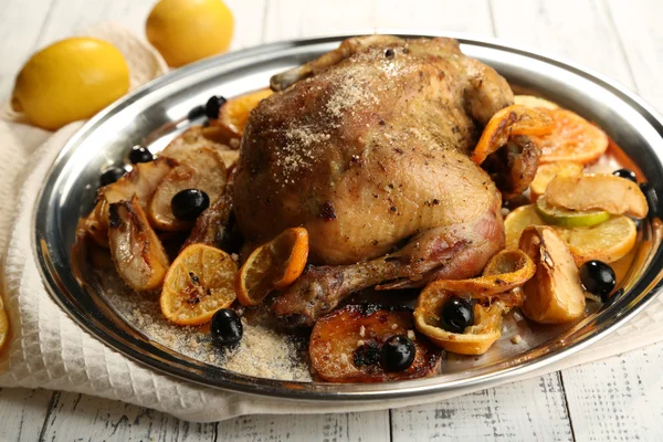 Whole roasted chicken with vegetables on tray, on wooden background — Stock Photo, Image