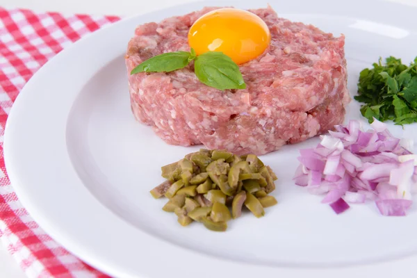 Delicious steak tartare with yolk on plate on table close-up — Stock Photo, Image