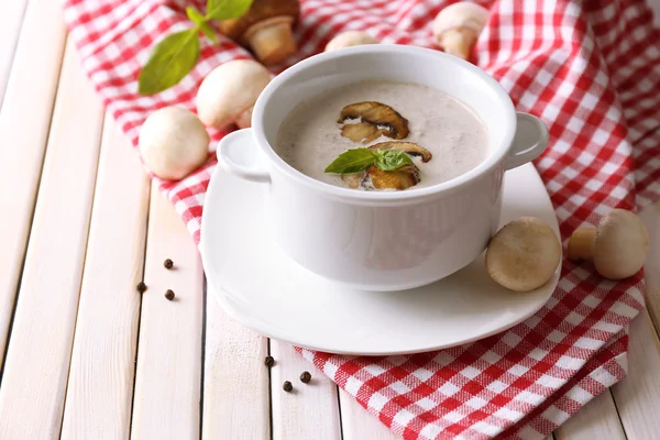 Грибной суп в белом горшке, на салфетке, на деревянном фоне — стоковое фото