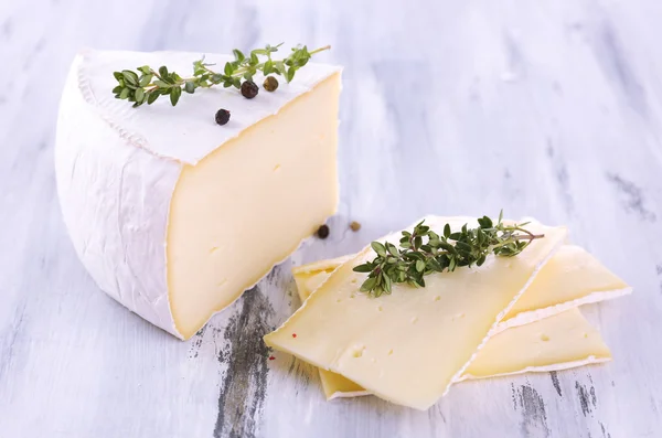 Schmackhafter Camembert-Käse mit Gewürzen, auf Holztisch — Stockfoto