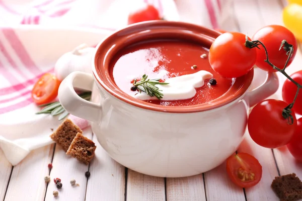 Smaczne zupa pomidorowa na drewnianym stole — Zdjęcie stockowe