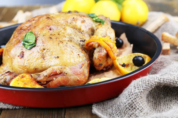 Pollo asado entero con verduras en sartén, sobre fondo de madera —  Fotos de Stock