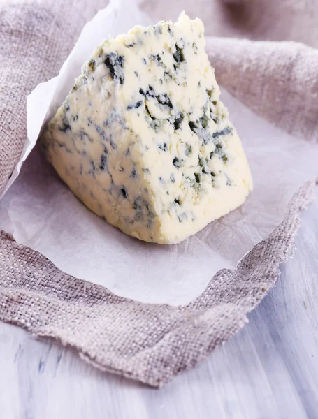 Smakelijke blauwe kaas op papier — Stockfoto