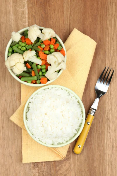 Gekookte rijst met groenten op houten tafel — Stockfoto