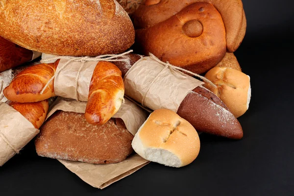 Olika typer av bröd på svart bakgrund, närbild — Stockfoto