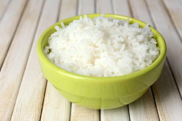 Nasi yang dimasak dalam mangkuk dengan latar belakang kayu — Stok Foto