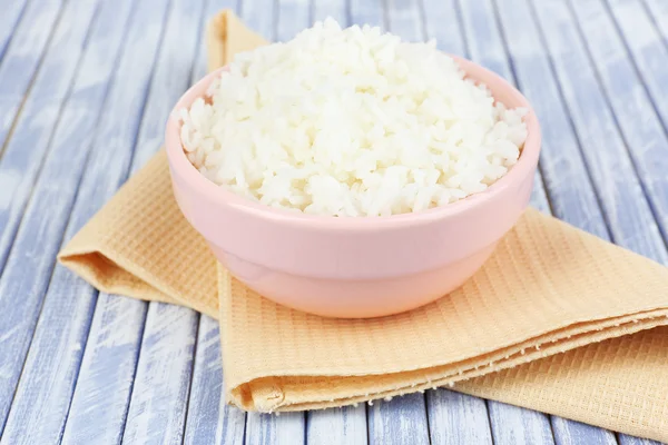 Cooked rice in bowl on wooden background — Stock Photo, Image