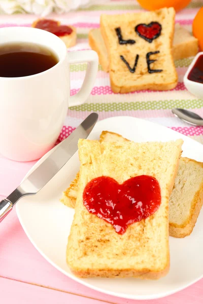 Roti panggang lezat dengan selai dan secangkir teh di meja close-up — Stok Foto