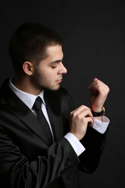 Bello giovane in giacca e cravatta su sfondo scuro — Foto Stock