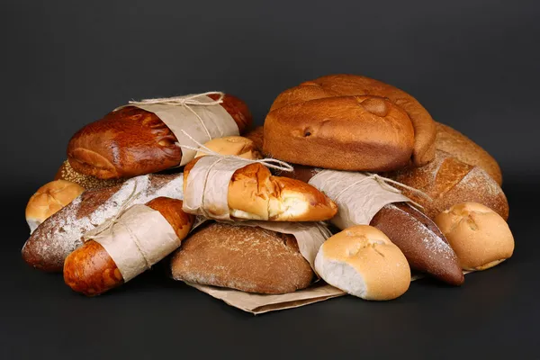 Diferentes tipos de pão no fundo preto, close-up — Fotografia de Stock