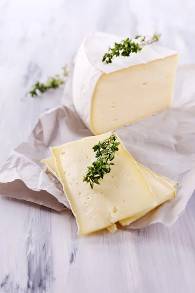 Sabroso queso Camembert con tomillo, sobre mesa de madera —  Fotos de Stock