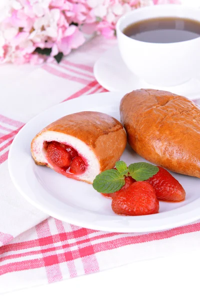 Fresh baked pasties with strawberries on plate on table close-up — Stock Photo, Image