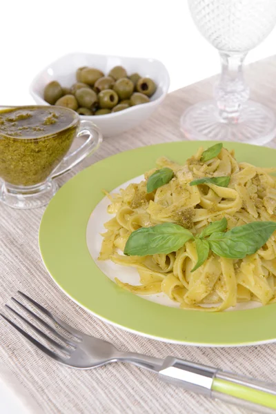 Läckra pasta med pesto på tallriken på bordet närbild — Stockfoto