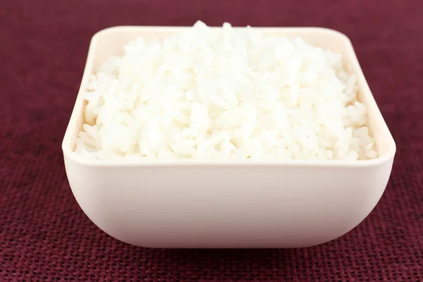 Приготований рис у мисці на червоному тлі — стокове фото