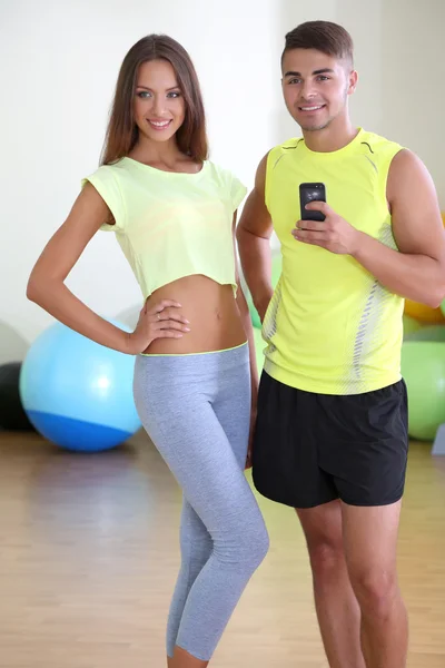 Facet i dziewczyna fotografowania w lustro na telefon w siłowni — Zdjęcie stockowe