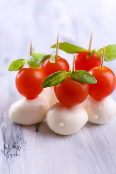 Gustosa mozzarella con basilico e pomodori, su tavola di legno — Foto Stock