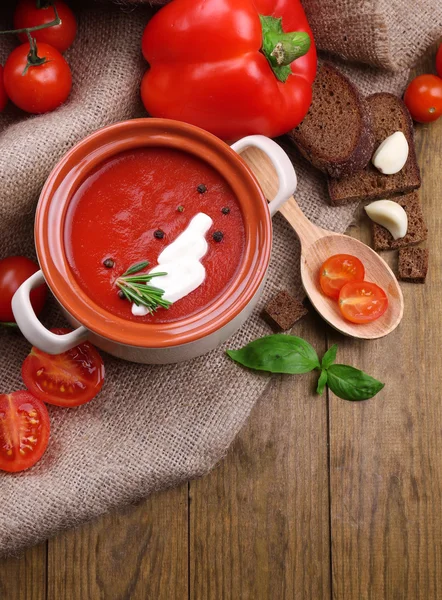 Smakelijke tomatensoep en groenten op houten tafel — Stockfoto