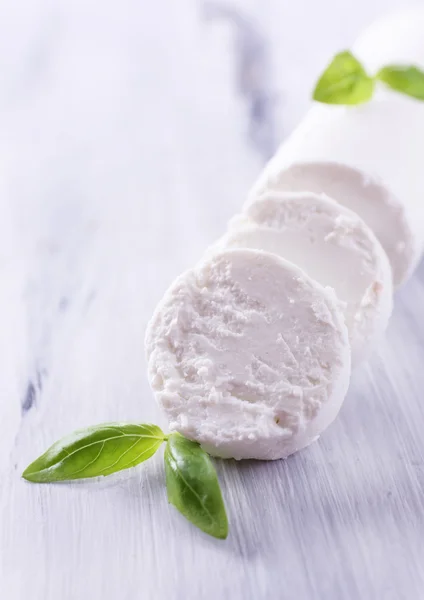 Sabroso queso de monte con albahaca, sobre mesa de madera — Foto de Stock