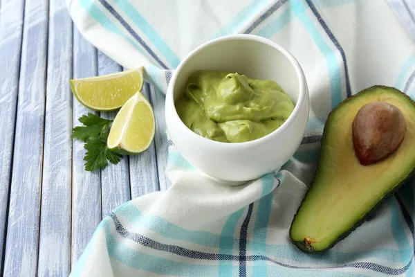 Fresh guacamole in bowl on wooden table — Stock Photo, Image