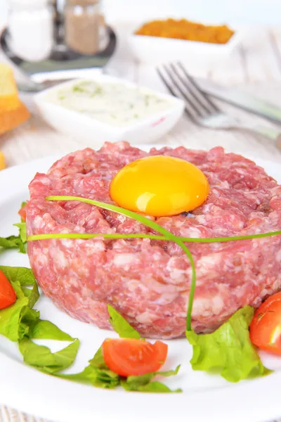 Delicious steak tartare with yolk on plate on table close-up — Stock Photo, Image