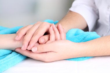 açık renkli hastanın elini tutarak tıp doktoru