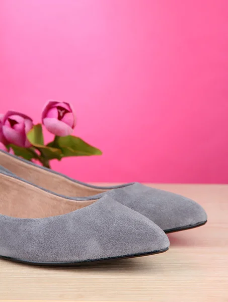 Belles chaussures et fleurs féminines grises sur fond rose — Photo