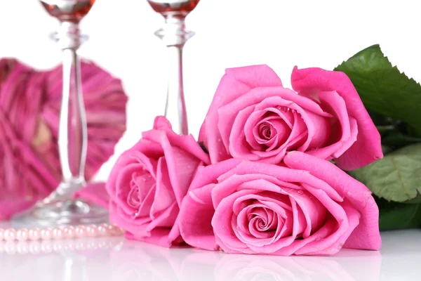 Composición con vino espumoso rosa en copas, y rosas rosadas aisladas en blanco — Foto de Stock