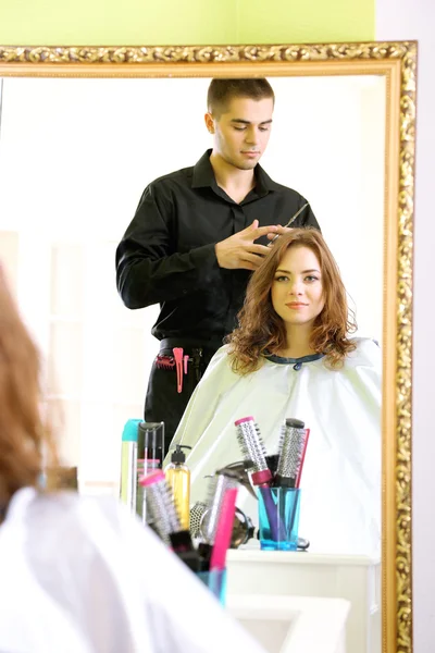 Joven peluquero hace peinado chica en salón de belleza —  Fotos de Stock