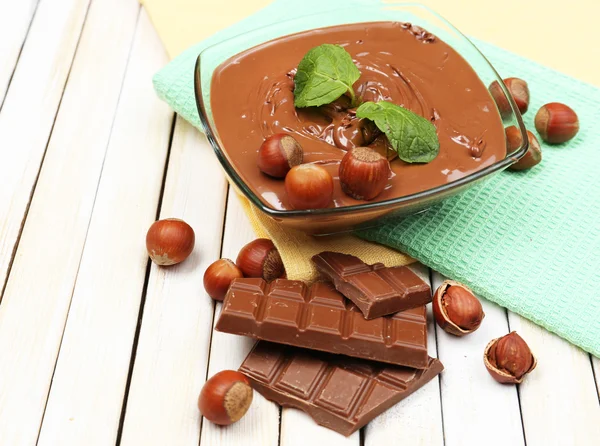 Süßer Schokoladen-Haselnussaufstrich mit ganzen Nüssen und Minze auf Holzgrund — Stockfoto