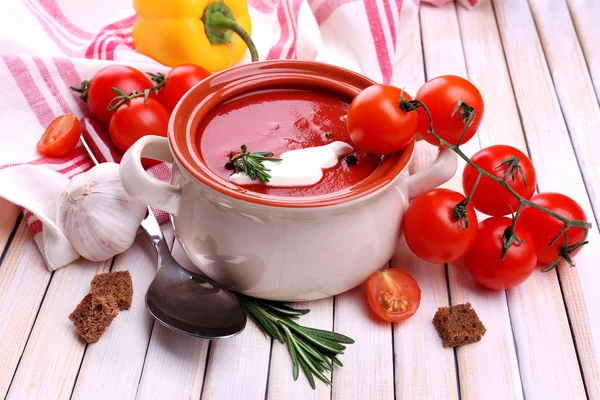 Smakelijke tomatensoep en groenten op houten tafel — Stockfoto
