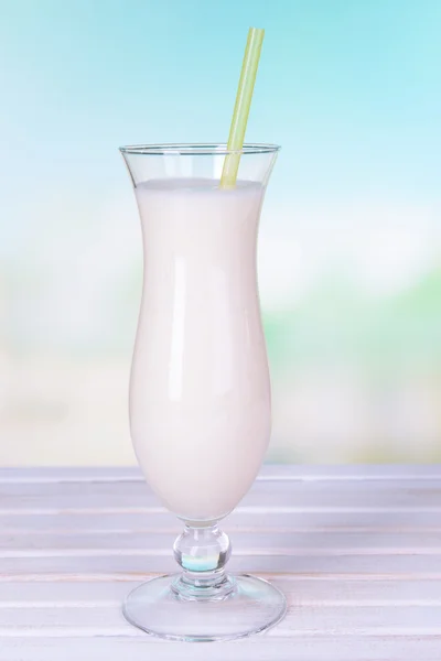 Milk shake on table on light blue background — Stock Photo, Image