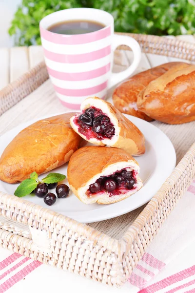 Fresh baked pasties with currant on plate on table close-up — Stock Photo, Image