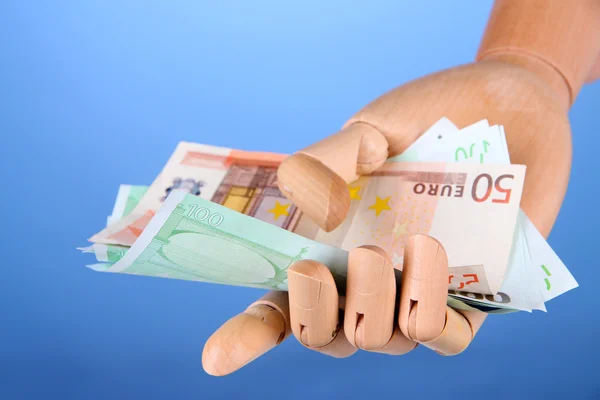 Geld in Holzhand, auf farbigem Hintergrund — Stockfoto