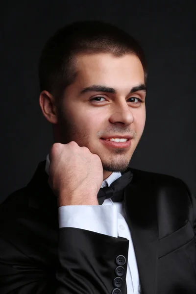 Hombre joven guapo en traje sobre fondo oscuro —  Fotos de Stock