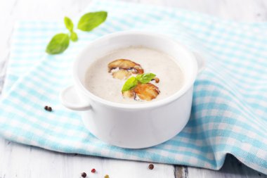 peçeteye ahşap arka plan üzerinde beyaz tencerede mantar çorbası