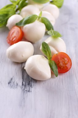 ahşap masa üstünde domates ve fesleğen ile lezzetli mozzarella peyniri