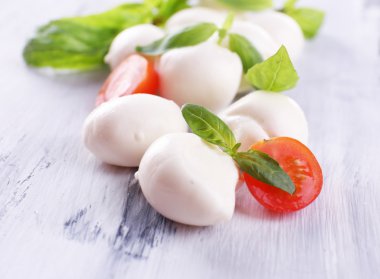 ahşap masa üstünde domates ve fesleğen ile lezzetli mozzarella peyniri