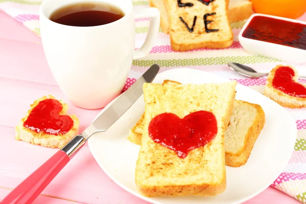 Delicious toast with jam and cup of tea on table close-up — Stock Photo, Image