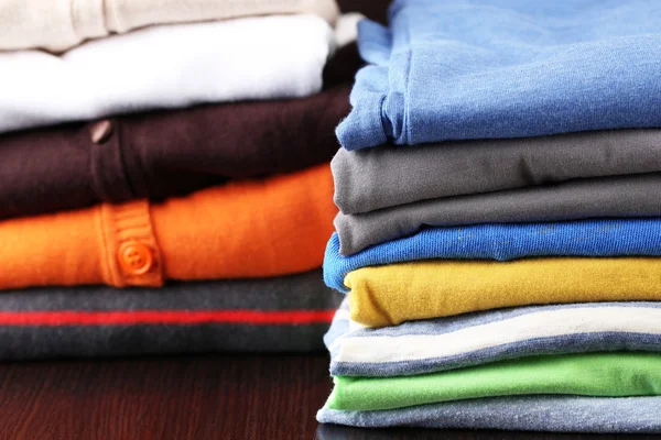 Stack of colorful clothes, on dark background — Stock Photo, Image