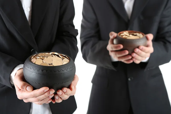 Two ceramic pots with golden coins in male and female hands, isolated on white background — Stock Photo, Image