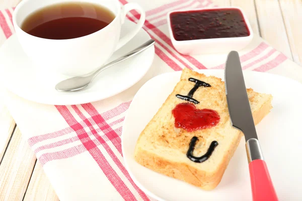 Delicioso brindis con mermelada y taza de té en primer plano de la mesa — Foto de Stock