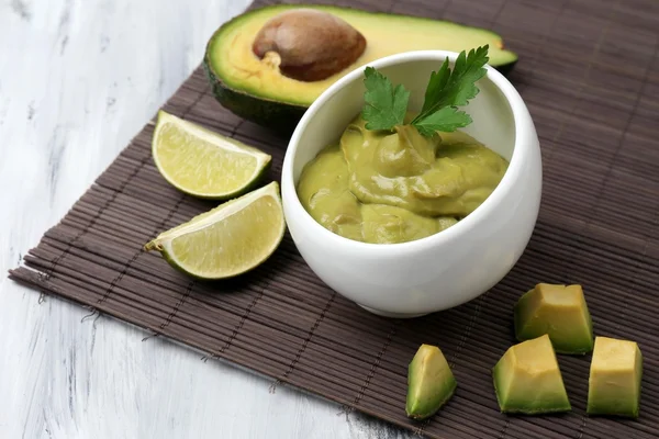 Guacamole fresco in ciotola sul tavolo di legno — Foto Stock