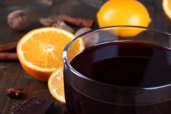 Vinho ruminado com laranja e especiarias em fundo de madeira — Fotografia de Stock