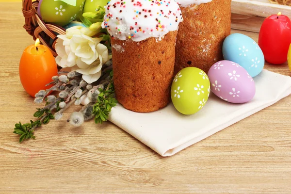 漂亮的复活节蛋糕、 彩蛋和木制的桌子上的蜡烛 — 图库照片