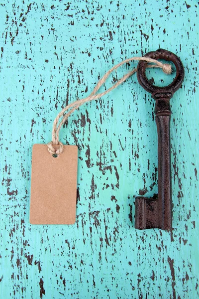 Key with empty tag, on color wooden background