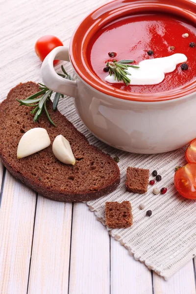 Smakelijke tomatensoep en groenten op houten tafel — Stockfoto